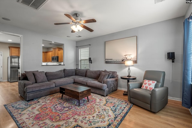 living room with ceiling fan and light hardwood / wood-style floors