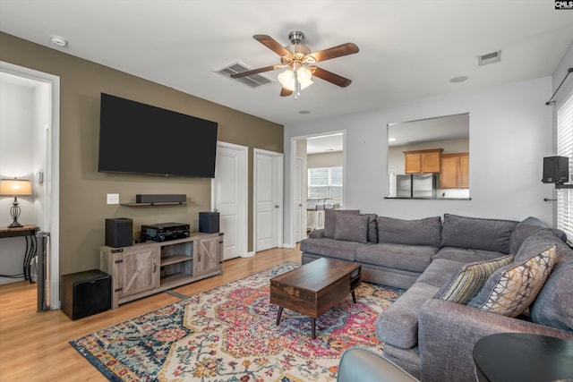 living room featuring ceiling fan and light hardwood / wood-style floors