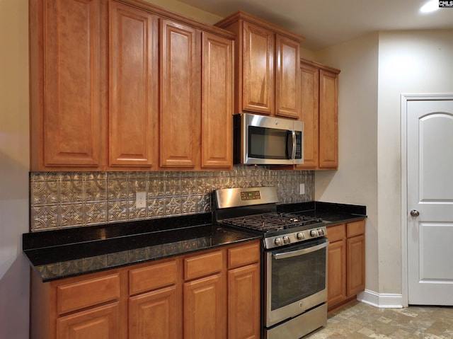 kitchen featuring tasteful backsplash, dark stone counters, and appliances with stainless steel finishes