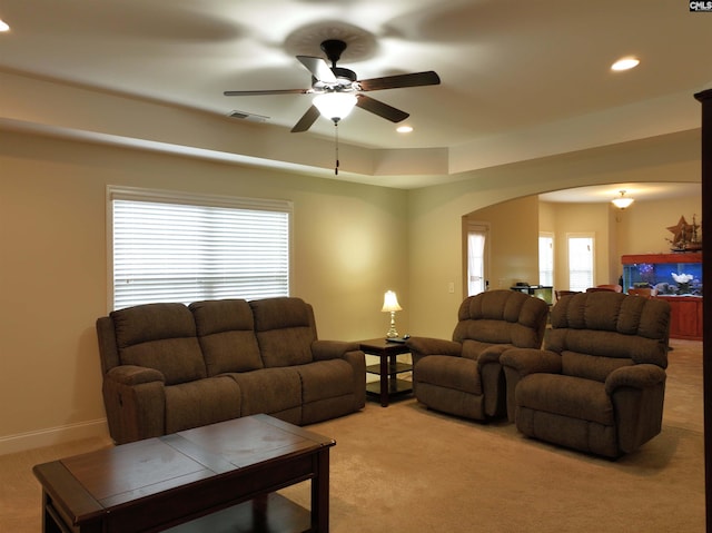 living room featuring ceiling fan, a healthy amount of sunlight, and light carpet