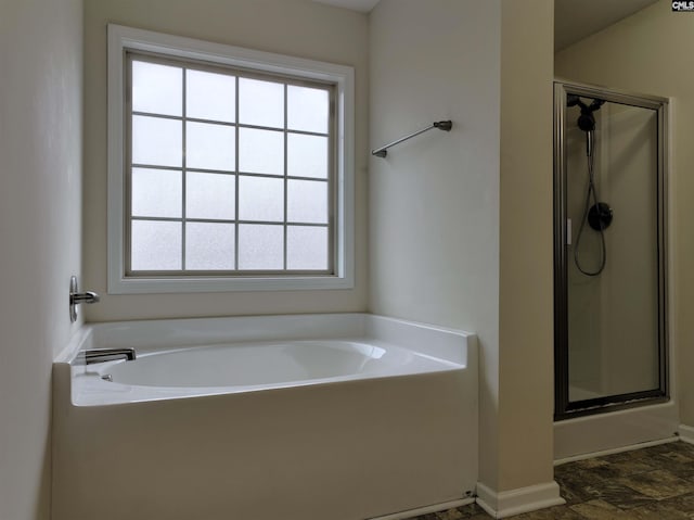 bathroom featuring separate shower and tub and a healthy amount of sunlight