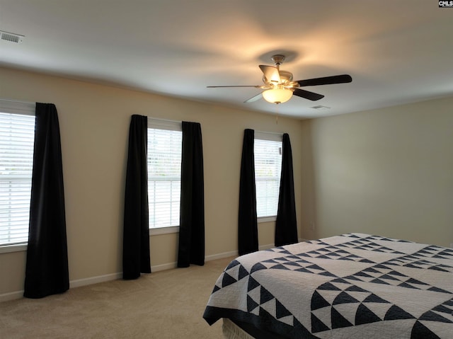 bedroom with ceiling fan and light carpet