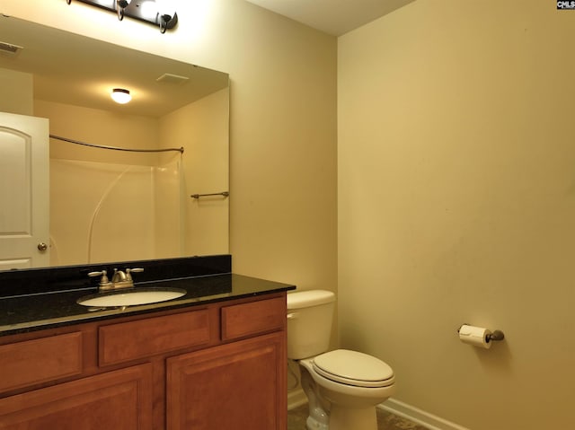 bathroom featuring vanity, toilet, and walk in shower