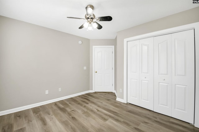 unfurnished bedroom with ceiling fan, light hardwood / wood-style floors, and a closet