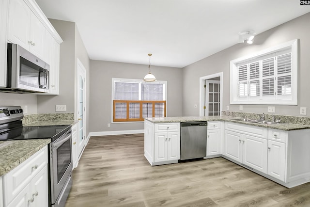 kitchen featuring pendant lighting, sink, appliances with stainless steel finishes, white cabinets, and kitchen peninsula