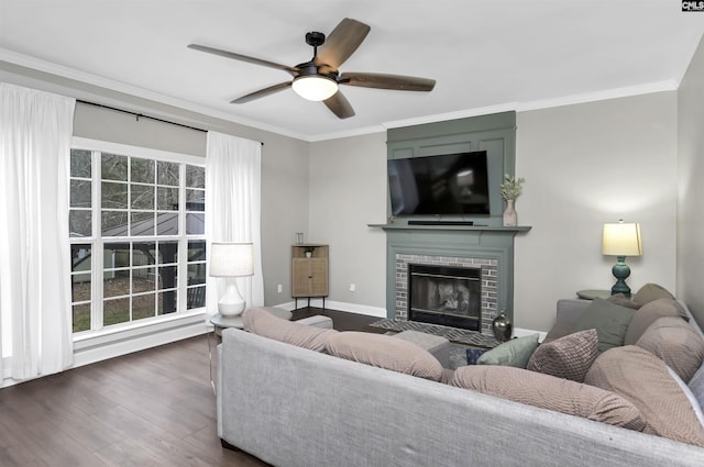 living room with a fireplace, dark wood-type flooring, ornamental molding, and ceiling fan