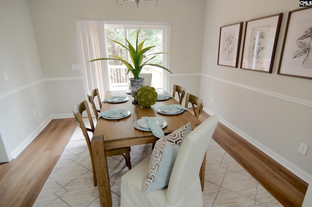 dining space with a notable chandelier and light wood-type flooring