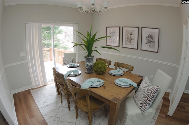 dining area featuring hardwood / wood-style flooring, ornamental molding, and a chandelier