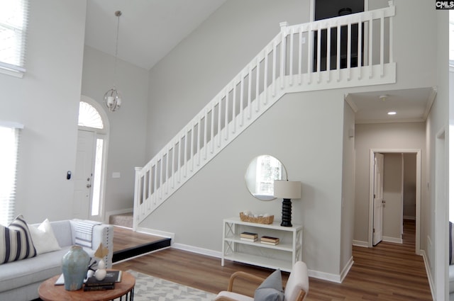 living room featuring a high ceiling, plenty of natural light, hardwood / wood-style flooring, and a notable chandelier