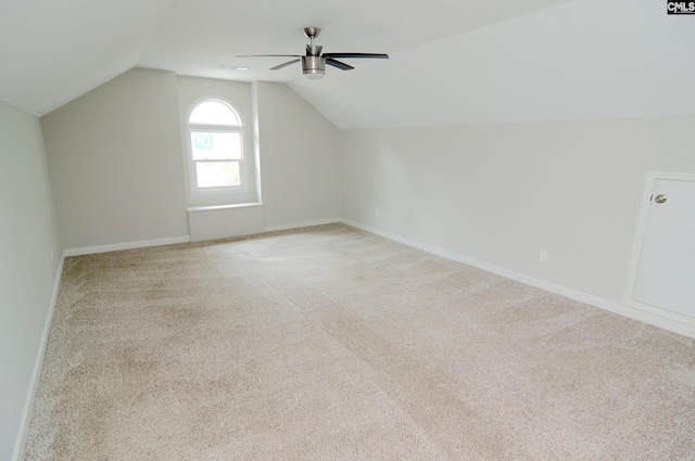 additional living space featuring vaulted ceiling, light colored carpet, and ceiling fan