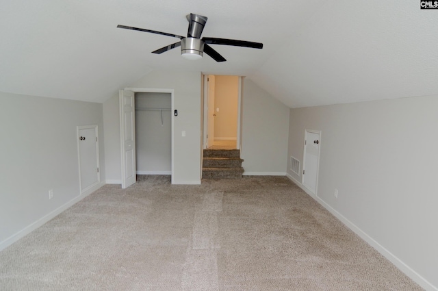 additional living space with lofted ceiling, light carpet, and ceiling fan