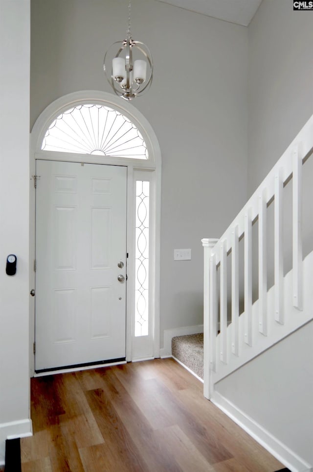 entrance foyer with wood-type flooring and a chandelier