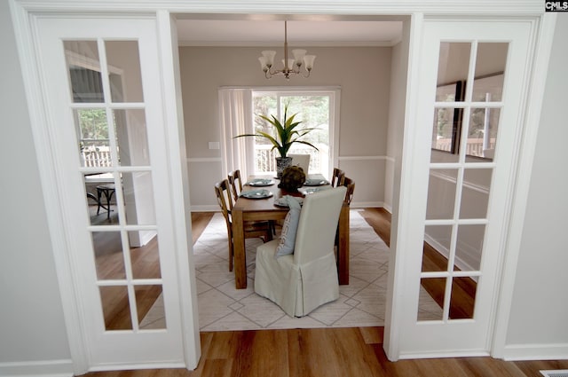 dining room featuring crown molding, a notable chandelier, and light hardwood / wood-style flooring