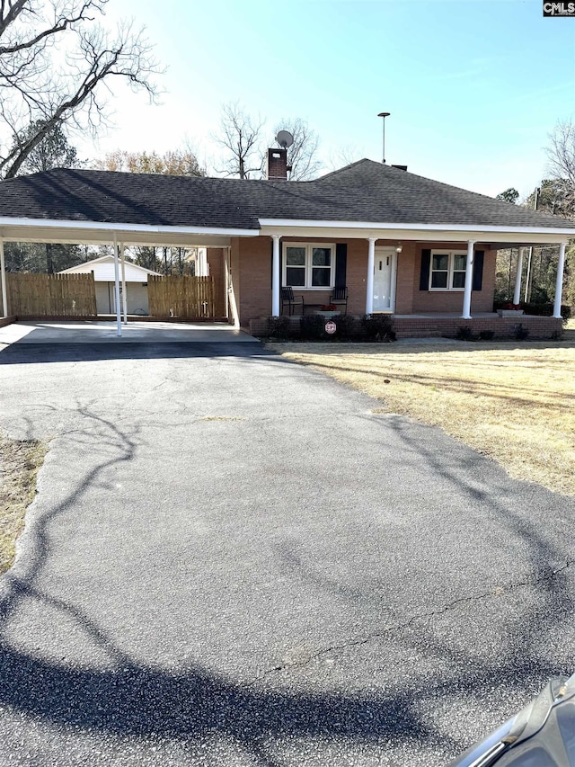 ranch-style house featuring a garage, an outdoor structure, and a porch