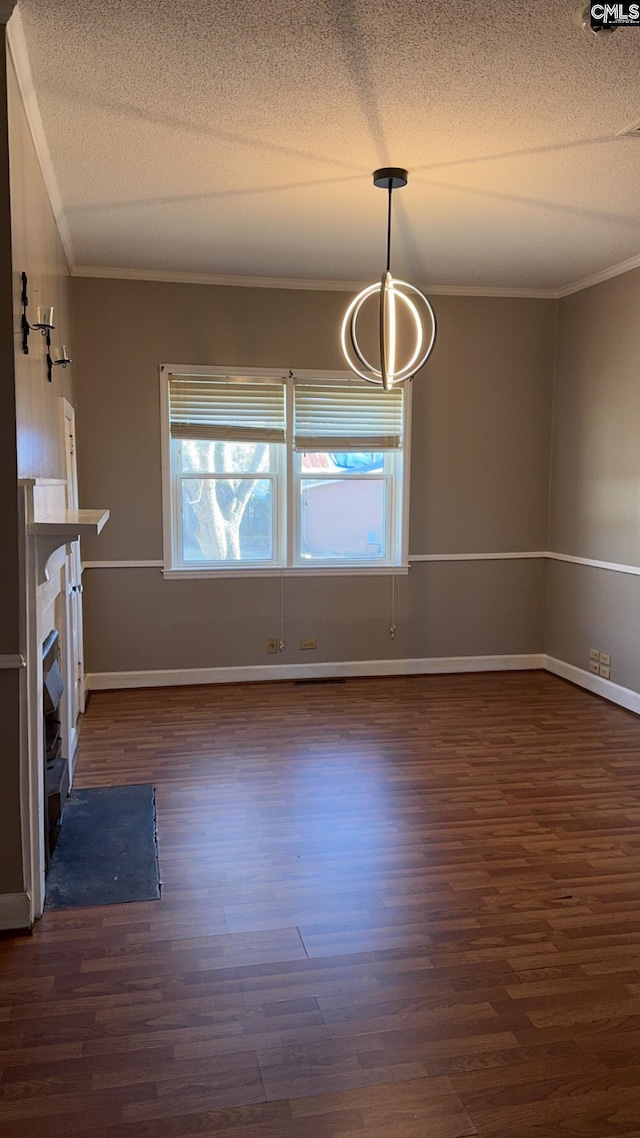 unfurnished dining area with crown molding, dark wood-type flooring, and a textured ceiling