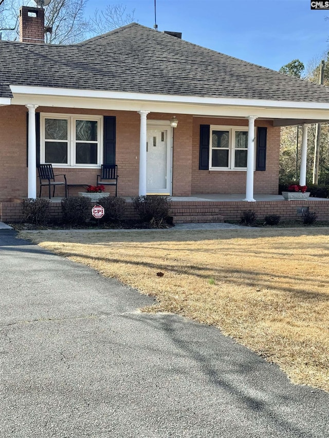 view of front of home with a porch and a front yard