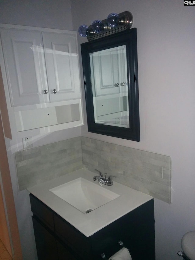 bathroom with tasteful backsplash and vanity