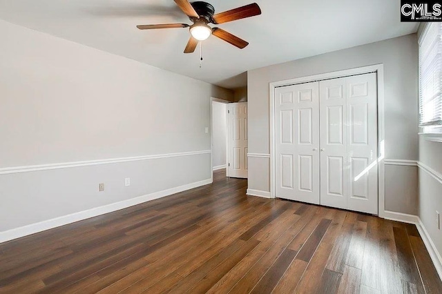 unfurnished bedroom featuring dark wood-type flooring, a closet, and ceiling fan