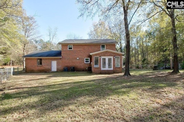 rear view of property featuring french doors, central air condition unit, and a lawn