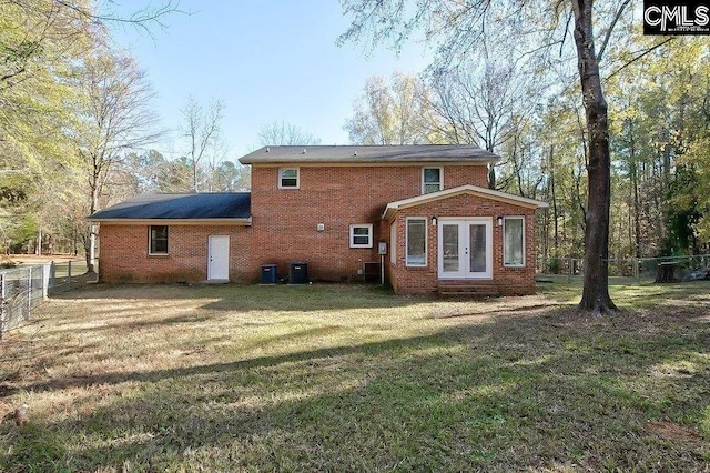 back of property with central AC unit, a lawn, and french doors