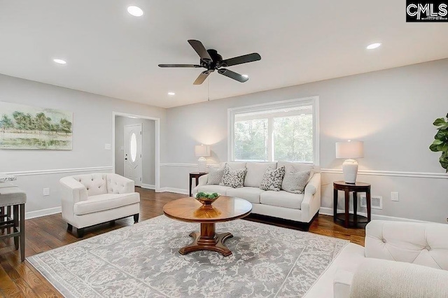 living room featuring ceiling fan and dark hardwood / wood-style flooring