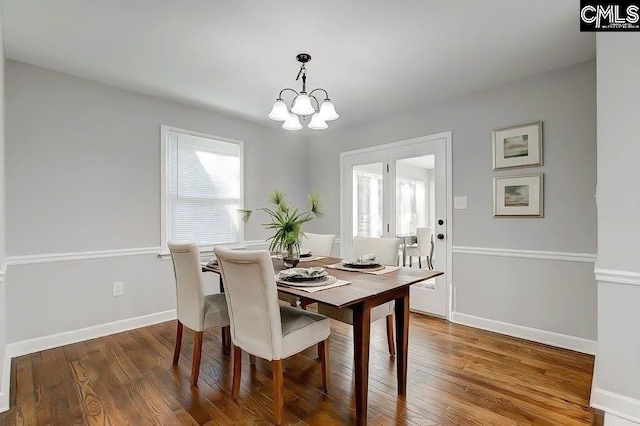 dining area with hardwood / wood-style flooring and a chandelier