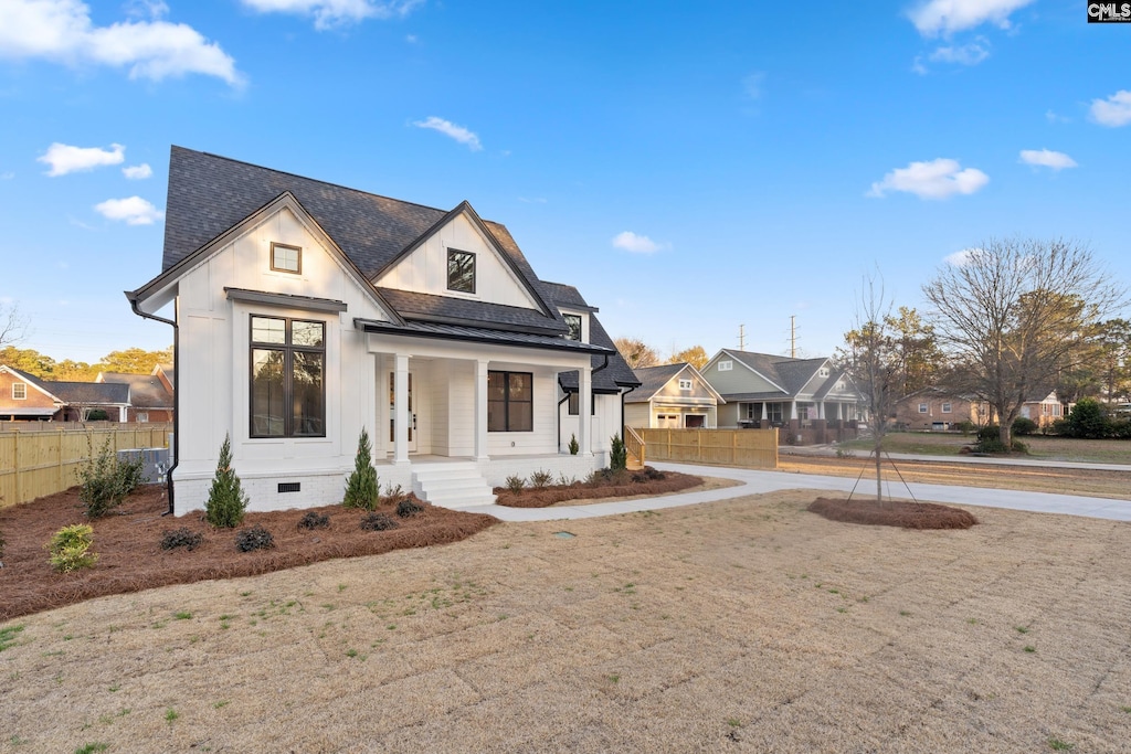 217 Alexandria St, West Columbia, SC 29169 - modern farmhouse style home with a porch, fence, a residential view, and roof with shingles