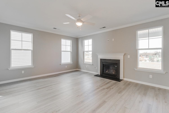 unfurnished living room with light wood finished floors, ornamental molding, a fireplace with flush hearth, and visible vents