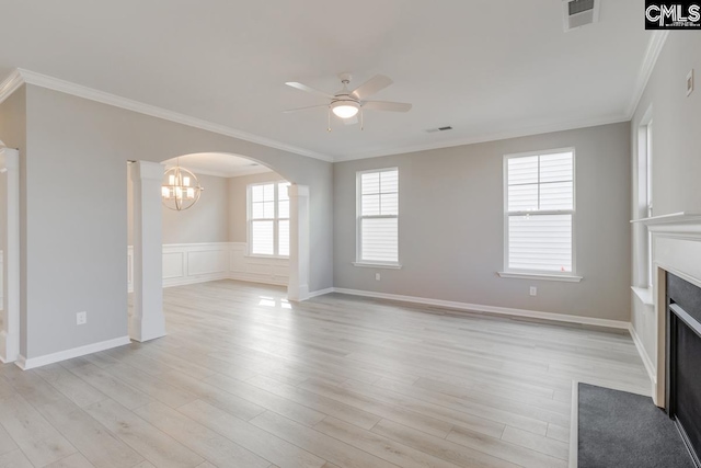 unfurnished living room featuring light wood finished floors, visible vents, arched walkways, a fireplace with flush hearth, and ceiling fan