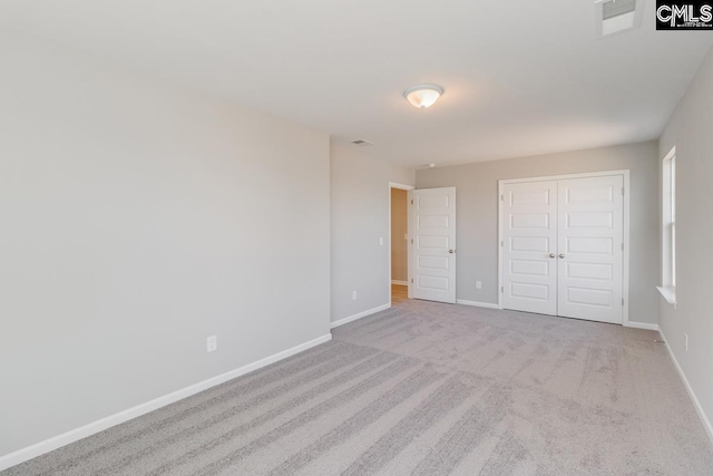 unfurnished bedroom featuring carpet, visible vents, baseboards, and a closet