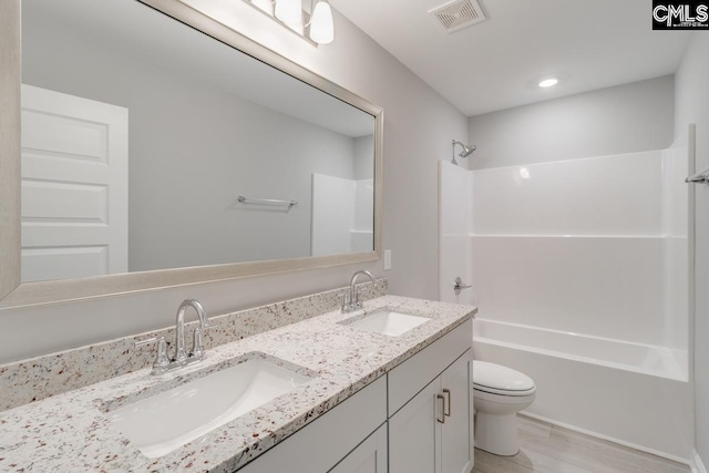 full bath with visible vents, a sink, toilet, and shower / bathtub combination