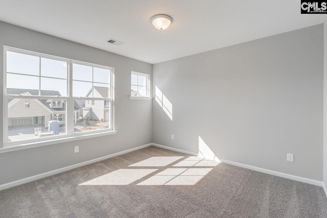 carpeted spare room with visible vents and baseboards