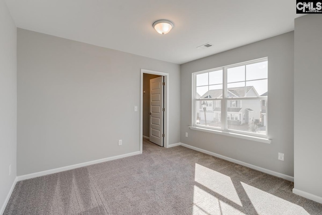 unfurnished bedroom with carpet floors, visible vents, and baseboards