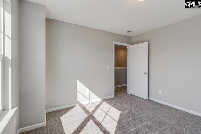 unfurnished room with carpet floors and baseboards