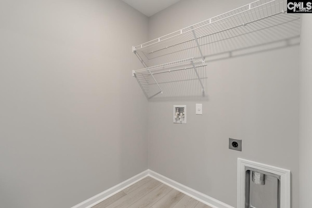 laundry room featuring hookup for a washing machine, laundry area, light wood-style floors, baseboards, and electric dryer hookup