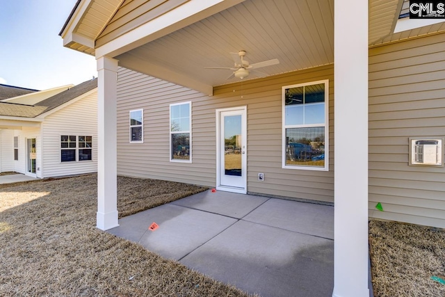 entrance to property with a ceiling fan and a patio area