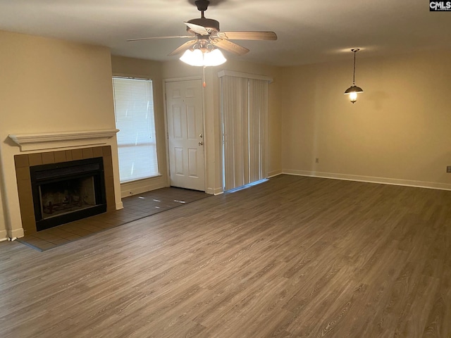 unfurnished living room with a fireplace, wood-type flooring, and ceiling fan