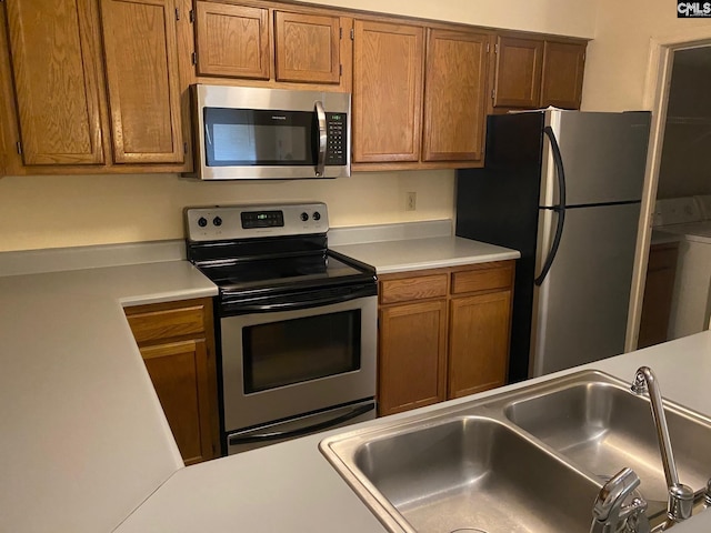 kitchen featuring sink, washer / dryer, and stainless steel appliances