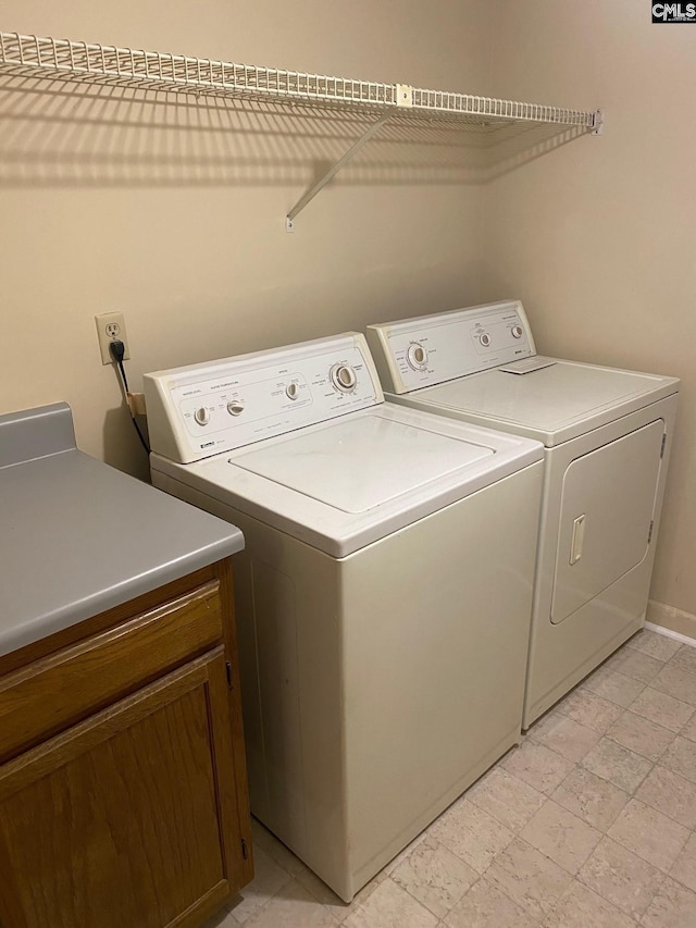 laundry area featuring cabinets and washer and clothes dryer