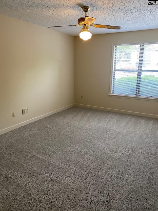 carpeted empty room featuring ceiling fan and a textured ceiling