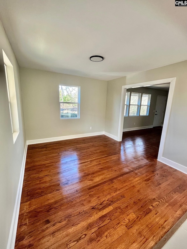 unfurnished room featuring dark hardwood / wood-style flooring and a wealth of natural light