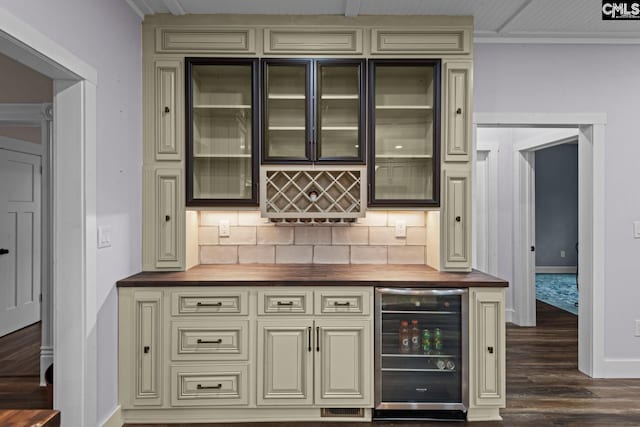 bar featuring wine cooler, dark wood-type flooring, butcher block countertops, tasteful backsplash, and cream cabinets