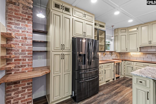 kitchen with butcher block counters, cream cabinets, decorative light fixtures, and stainless steel refrigerator with ice dispenser