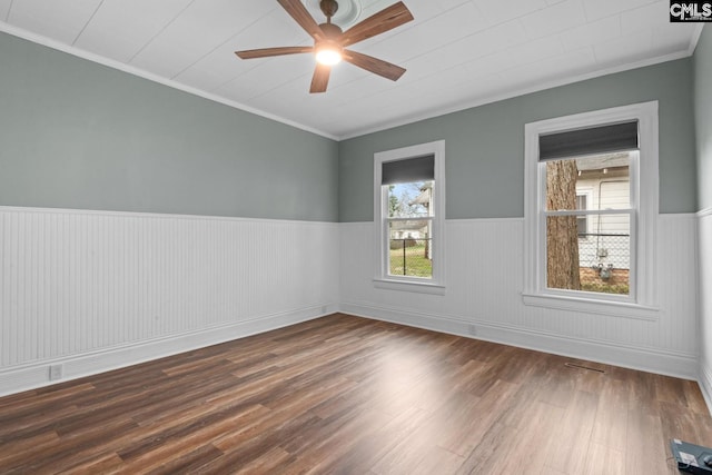 spare room with ornamental molding, dark wood-type flooring, and ceiling fan