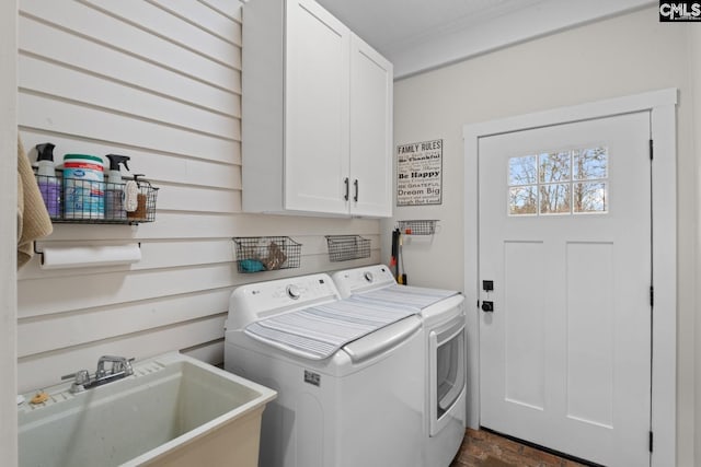 laundry area with cabinets, separate washer and dryer, and sink