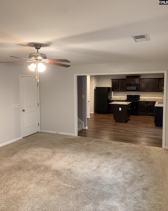 unfurnished living room with ceiling fan and dark colored carpet