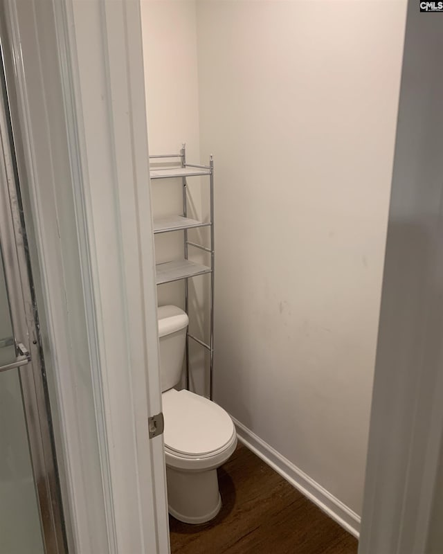 bathroom featuring hardwood / wood-style flooring and toilet