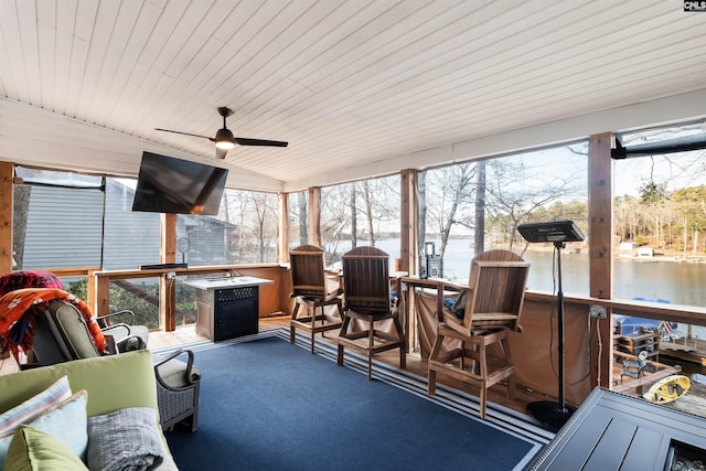 sunroom / solarium with a water view and ceiling fan