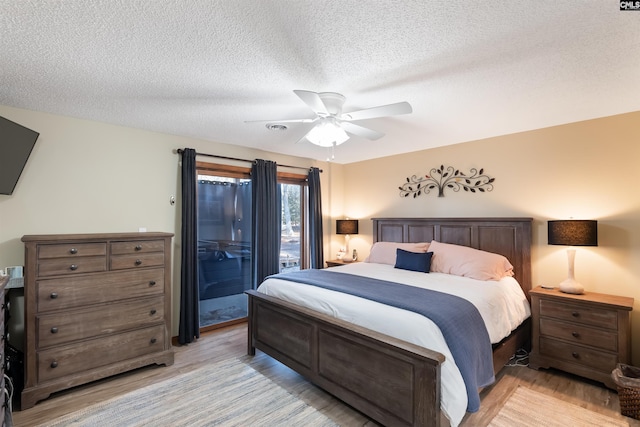 bedroom with ceiling fan, a textured ceiling, access to exterior, and light hardwood / wood-style floors