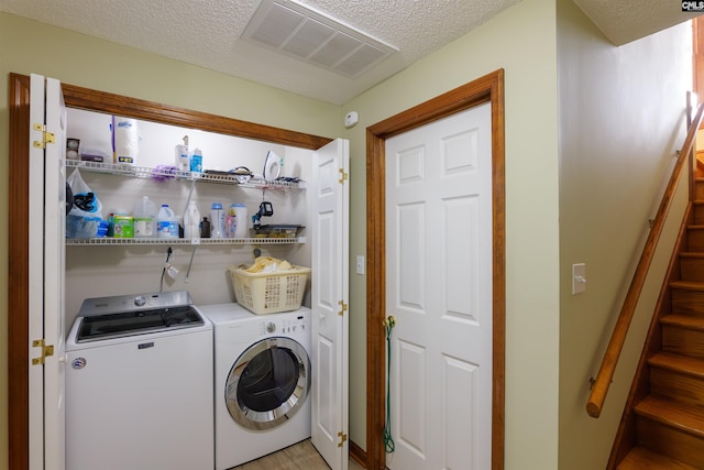 laundry room with washer and dryer and a textured ceiling